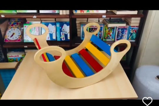Colorful wooden toy with handles on a table, displayed on a smartphone screen.
